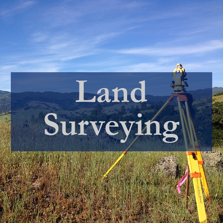 A land surveyor using equipment in a field under a clear blue sky.